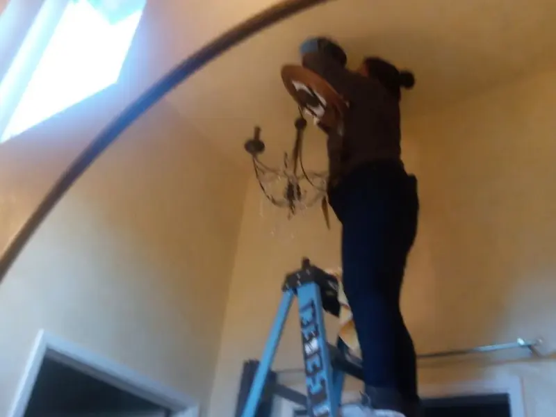 Electrician installing a chandelier in a Millbrae residence